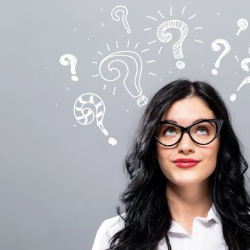 headphones open-air woman with glasses long hair thinking gray background 